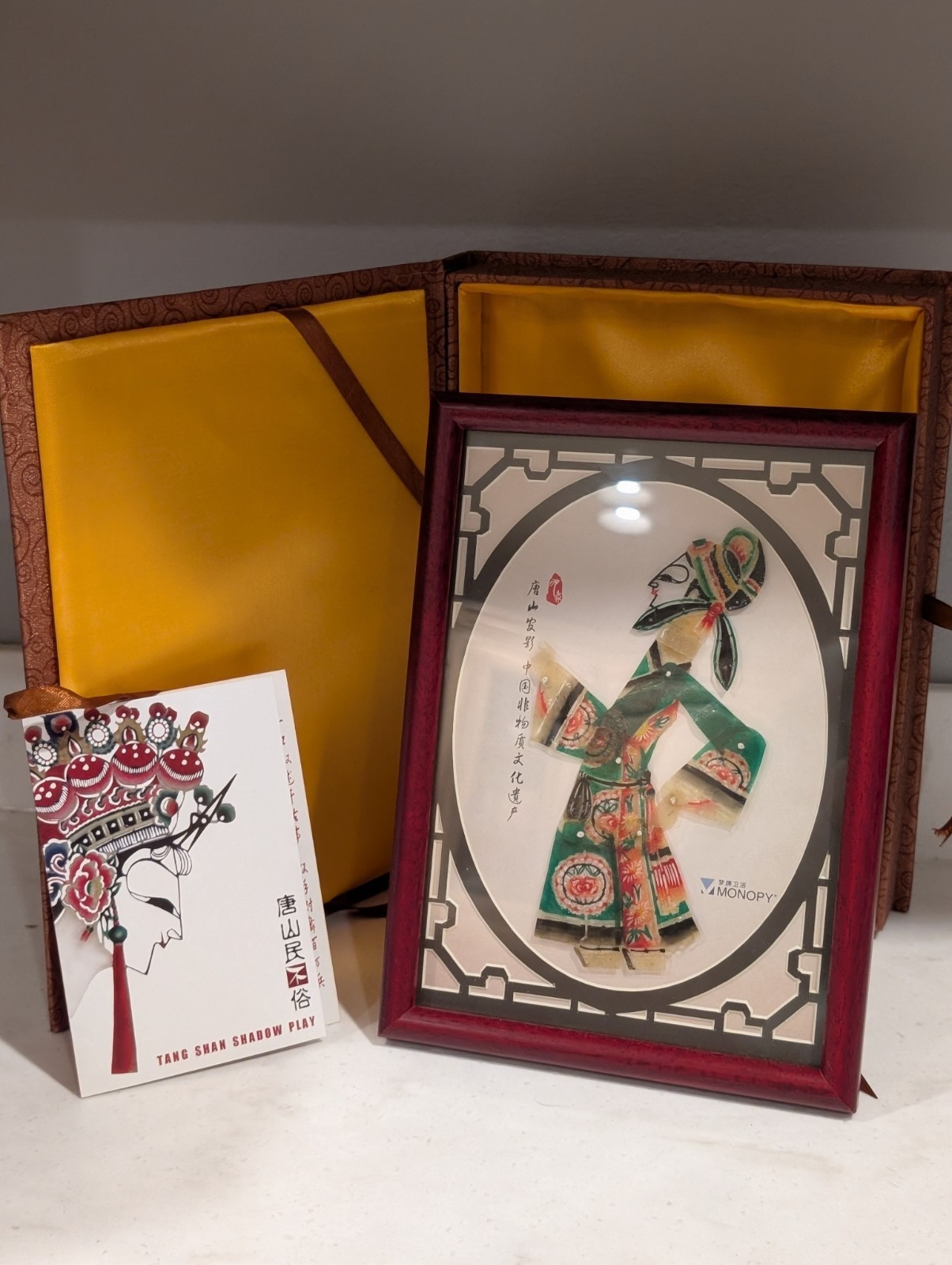 Vintage Chinese silk brocade gift box containing a Tang Shan shadow play item.